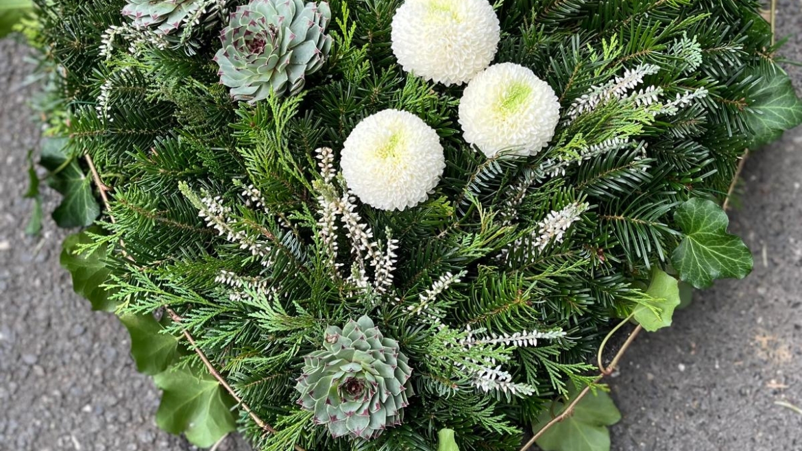 Allerheiligengesteck in Herzform mit weißen Chrysanthemen